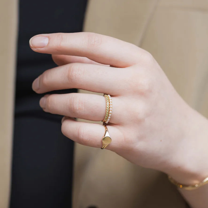parel en peridot stapelring, geboortesteen of birthstone van augustus en juni met een zegelring als pinkring